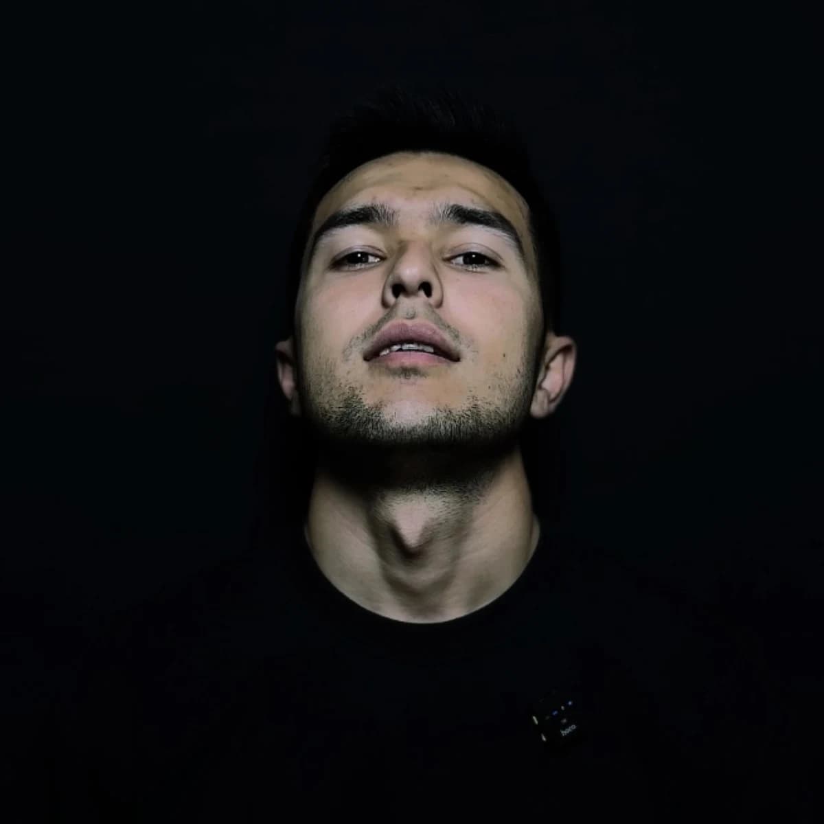 Portrait of Halim against a dark background